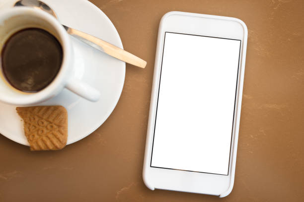 Shallow focus close up image of a cappuccino and a smartphone on the table in the cafe in Kreuzberg.