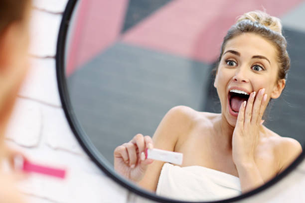 istock Young woman with pregnancy test in bathroom 1066627310