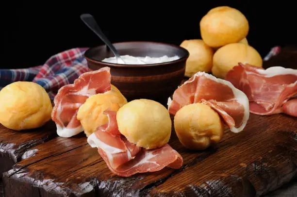 Photo of Coccoli is an appetizer from Italy. Pizza dough balls are fried and sprinkled with salt, served with prosciutto and cheese. Traditional Food During Christmas Period.They are also called pittule o pettole,I Coccoli toscani,Coccoli Fiorentini .