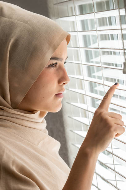 em causa jovem muçulmana, olhando por uma janela - hijab profile teenager islam - fotografias e filmes do acervo