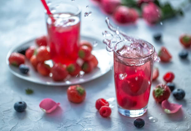 refreshing summer ice lemonade with fresh berries, roses on white background - strawberry blueberry raspberry glass imagens e fotografias de stock