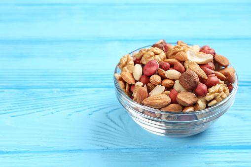 bowl with different mixed nuts on a blue table
