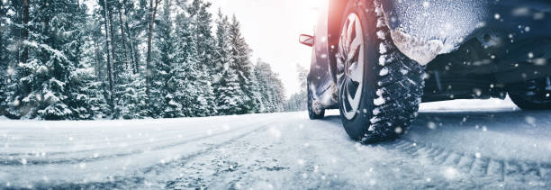 крупным планом автомобильных шин зимой на дороге - winter driving стоковые фото и изображения