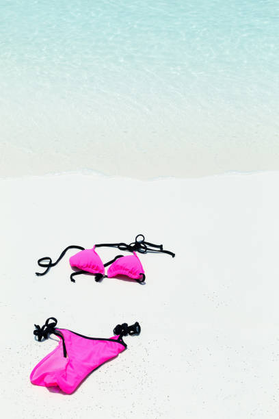 istock Swimsuit lying on white sand close to sea 1066675110