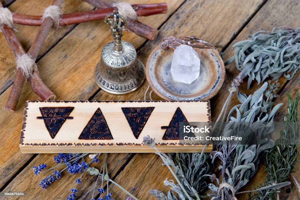 Lo elementos - tierra, fuego, agua, aire con campana de bronce, cristal de cuarzo, rama pentagram y paquetes de secado hierbas - Foto de stock de Altar libre de derechos