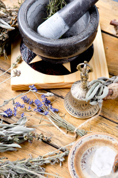 istock Mortar and Pestle on pentacle altar tile with dried herbs, brass bell, quartz crystal 1066675996