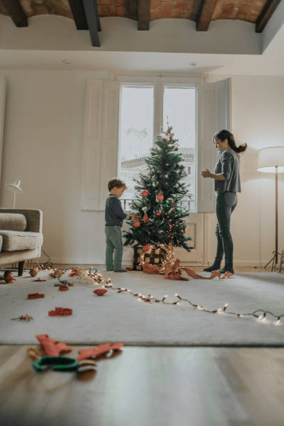 familie schmückt weihnachtsbaum - christmas decoration photography themes christmas ornament stock-fotos und bilder