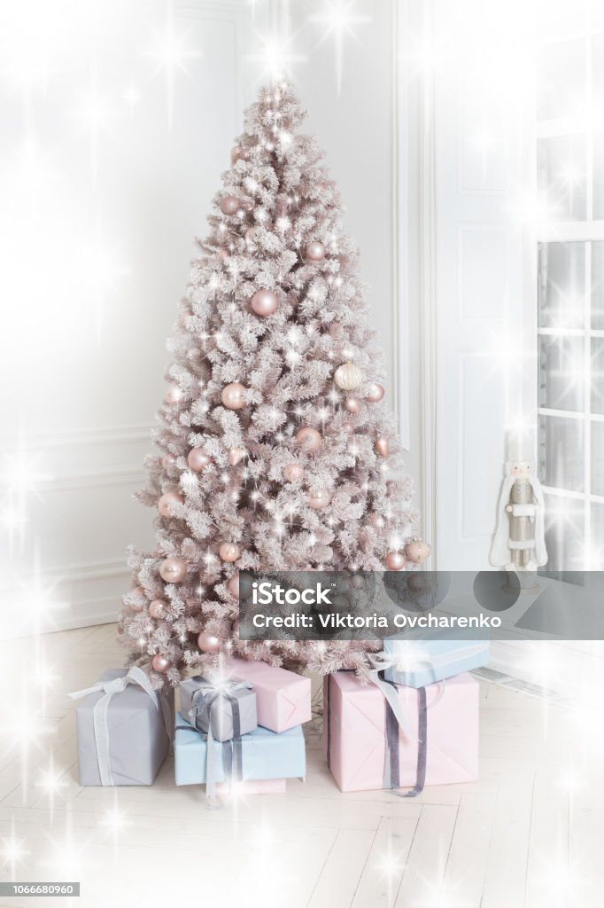 Beautiful holiday decorated Christmas tree and presents. White and silver christmas tree decoration with gold garland. New Year card Box - Container Stock Photo