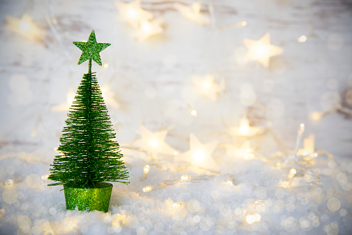 Bright Green Christmas Tree On Snow With Star On Top. Glittering, Sparkling And Shiny Fairy Lights. Snowy And Snow Background