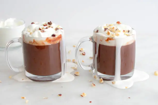 Hot chocolate topped with whipped cream and chopped hazelnuts