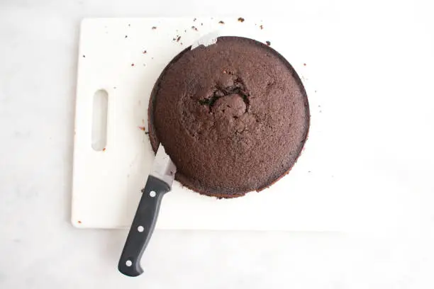 Using a serrated knife to level a chocolate cake