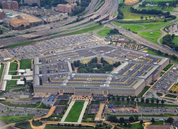 Aerial view of the United States Pentagon, the Department of Defense headquarters in Arlington, Virginia, near Washington DC, with I-395 freeway and the Air Force Memorial and Arlington Cemetery nearby. stock photo