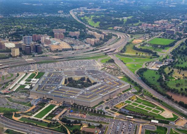 Aerial view of the United States Pentagon, the Department of Defense headquarters in Arlington, Virginia, near Washington DC, with I-395 freeway and the Air Force Memorial and Arlington Cemetery nearby. stock photo