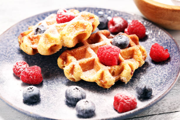 istock waffles with fresh blueberries, sugar and raspberries. 1066711562