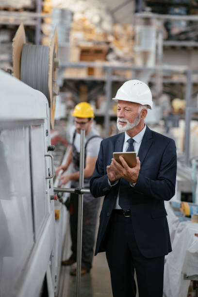 istock Senior engineer in factory controlling production line 1066711584