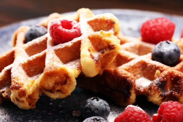 istock waffles with fresh blueberries, sugar and raspberries. 1066711640