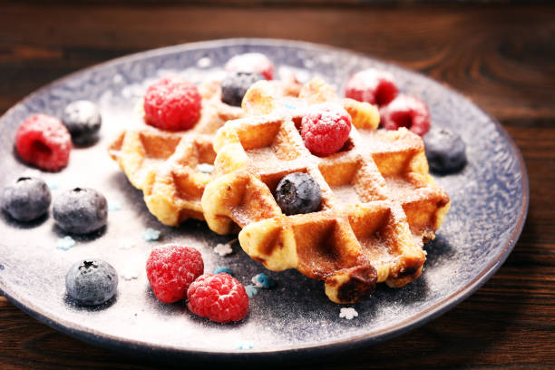 istock waffles with fresh blueberries, sugar and raspberries. 1066711870