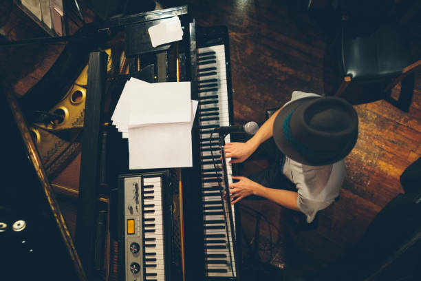 pianist in stadium durchführen - piano keyboard instrument one person piano key stock-fotos und bilder