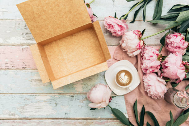 istock Beautiful pink peony, coffee cup and empty box on vintage background. Top view, flat lay 1066724560