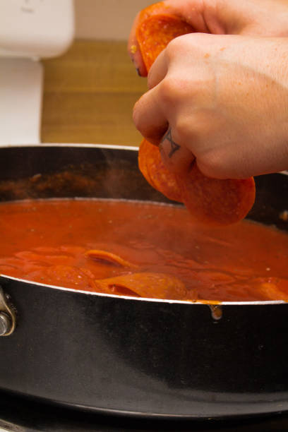istock Placing Pepperoni in Pasta Sauce 1066724726