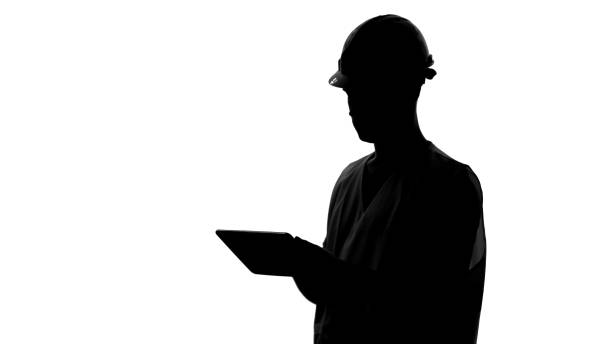 istock Silhouette of construction engineer in helmet holding tablet, architecture 1066728574