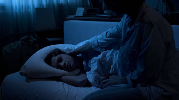 istock Loving mom looking at her sleeping son at night time feeling nostalgic, family 1066730460