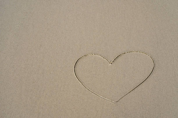 istock valentines day heart drawn on the sand beach 1066734470