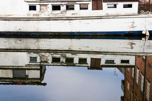 Abstract of an old white canal boat reflected in the water