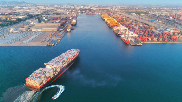 istock Aerial view container ship to sea port and working crane bridge loading container for logistics import  export or transportation concept background. 1066764300