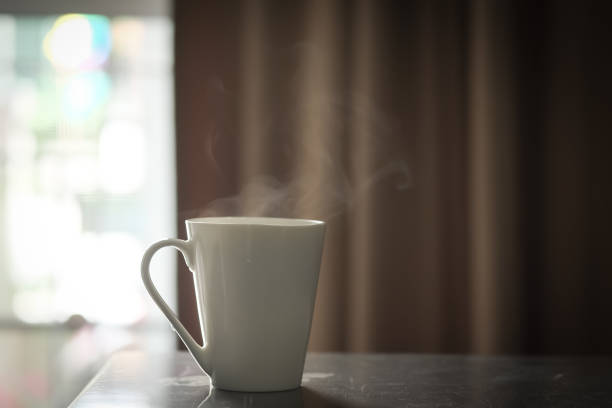 istock Hot coffee in white cup on a wooden table at morning 1066766726