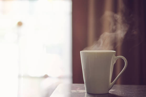 istock Hot coffee in white cup on a wooden table at morning 1066766742