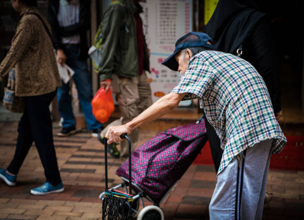 elder man walking the city streets of Hong Kong stock photo