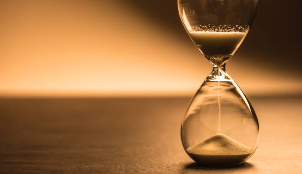 istock Modern hourglass in running time in studio lights. 1066799698
