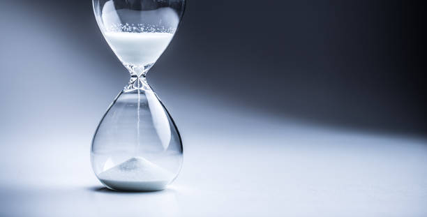istock Modern hourglass in running time in studio lights. 1066799702