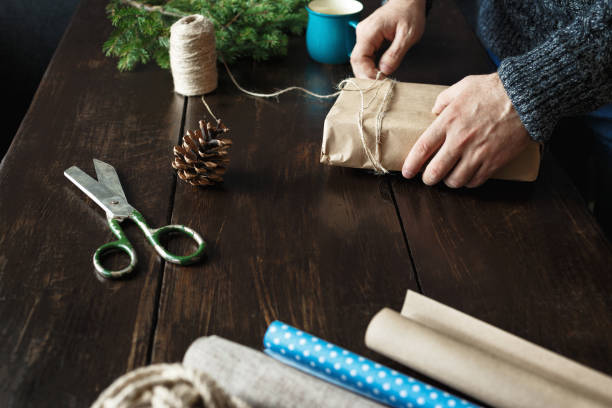 istock Male hands preparing Christmas present wooden table Rustic Christmas background 1066802190