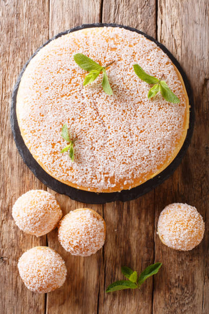 istock Large and small tropezienne cakes with delicate cream decorated with pearl sugar and mint close-up. Vertical top view 1066821192