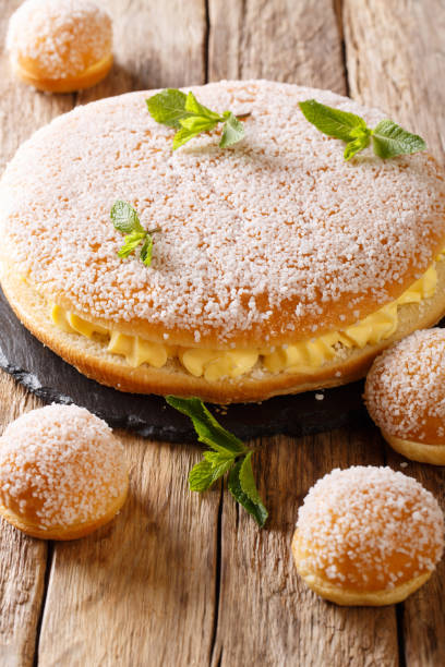 istock Large and small tropezienne cakes with delicate cream decorated with pearl sugar and mint close-up. vertical 1066823084
