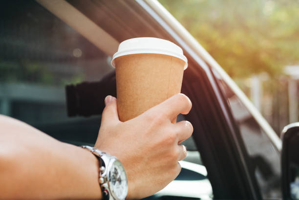 istock Hand holding takeaway coffee in a car 1066826404