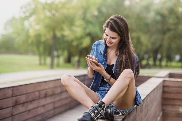 istock Beautiful girl using smart phone in a city 1066833598