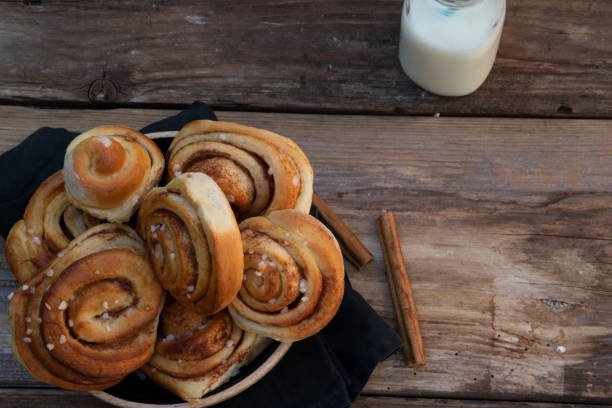 Danish Cinnamon rolls with a glas of milk on a wooden background stock photo