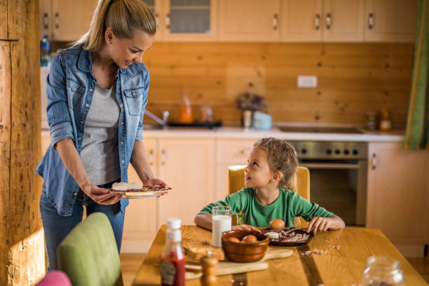istock Happy mother and daughter communicating during breakfast time at dining room. 1066842580