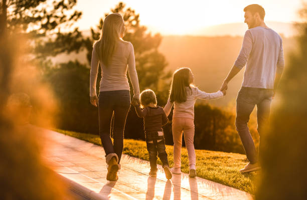 istock Back view of a family communicating while taking a walk at sunset. 1066842842