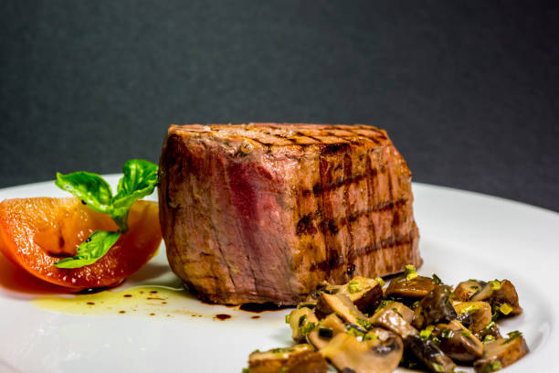istock Roasted meat with tomatoes and mushrooms on a white plate 1066855228