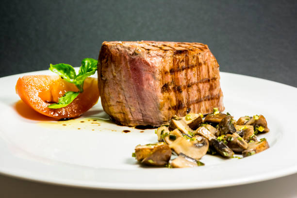 istock Roasted meat with tomatoes and mushrooms on a white plate 1066860438