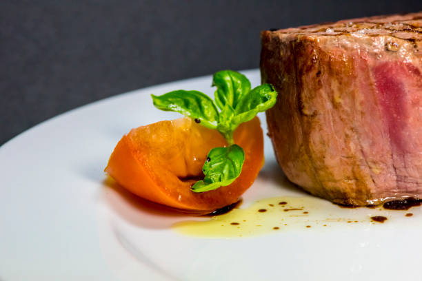 istock Roasted meat with tomatoes and mushrooms on a white plate 1066862916