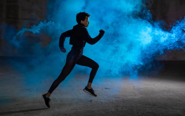 istock Young Woman Running With Blue Smoke Behind Her 1066864076