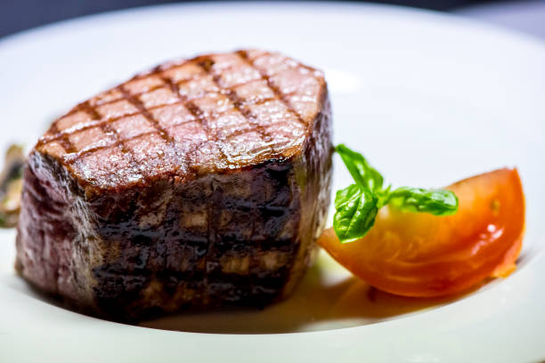 istock Roasted meat with tomatoes and mushrooms on a white plate 1066865206