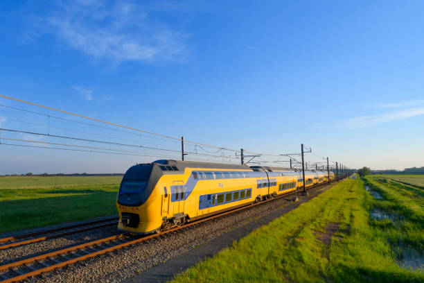ic-trein van de nederlandse spoorwegen rijden in lente landschap - ns stockfoto's en -beelden