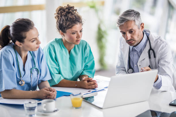istock Team of medical experts cooperating while using laptop in the hospital. 1066866772