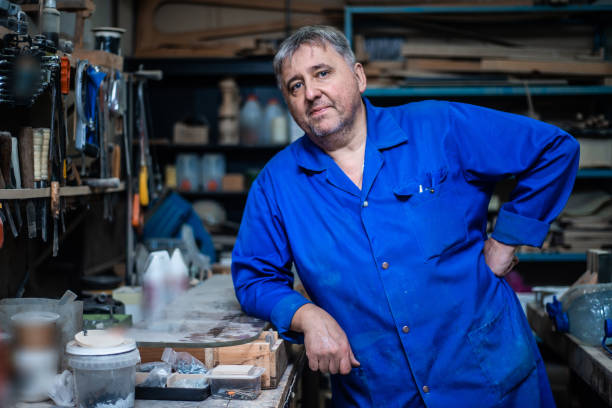 istock Mature carpenter approaches the camera and stands in a confident pose in his workshop 1066868006